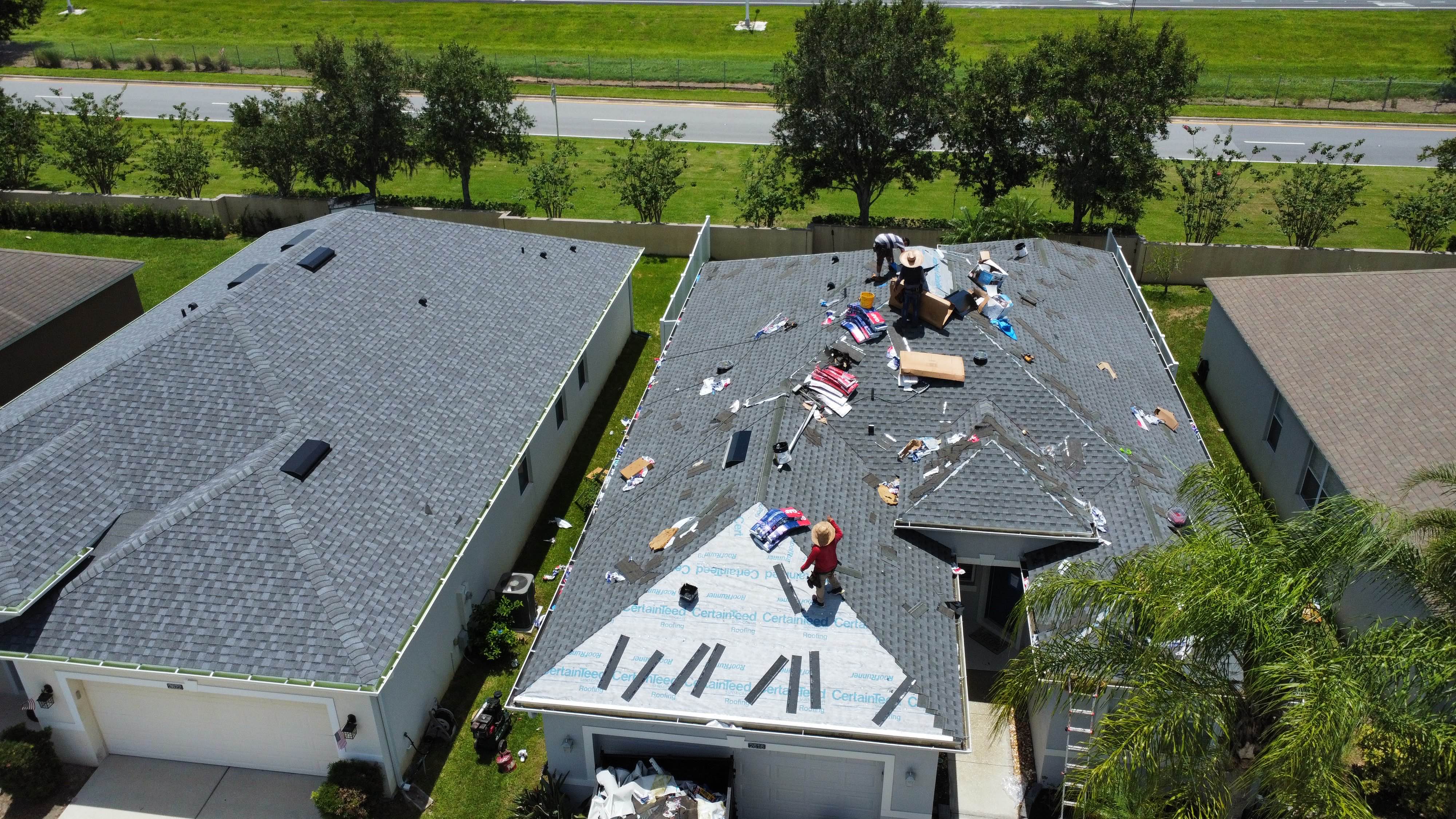 Workers installing new CertainTeed shingles on a Florida home
