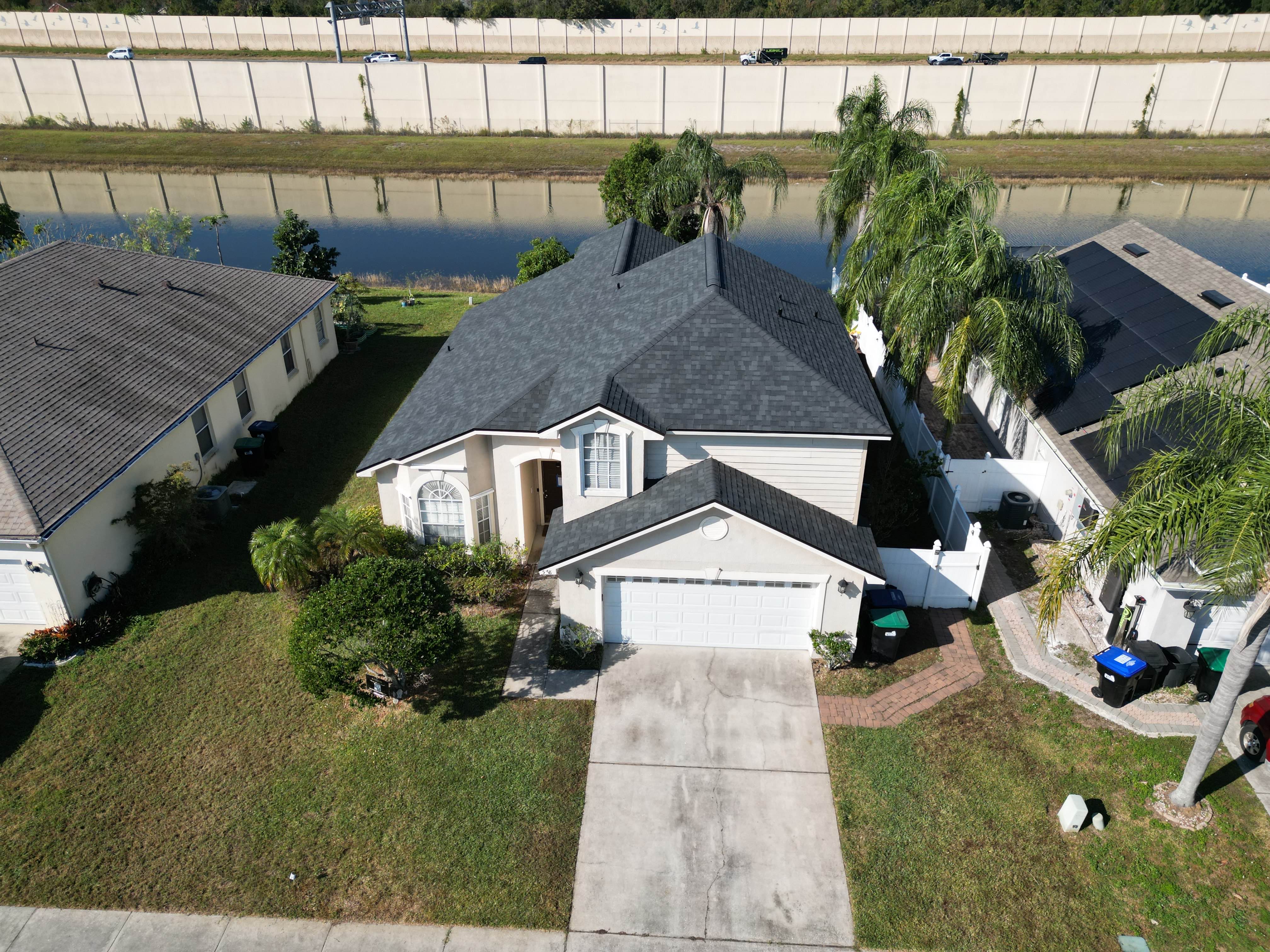 Completed dark shingle roof installed by Midas Roofing