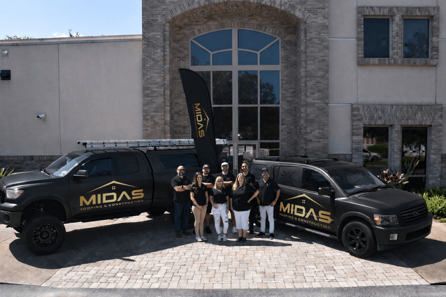 Midas Roofing & Construction team with branded vehicles